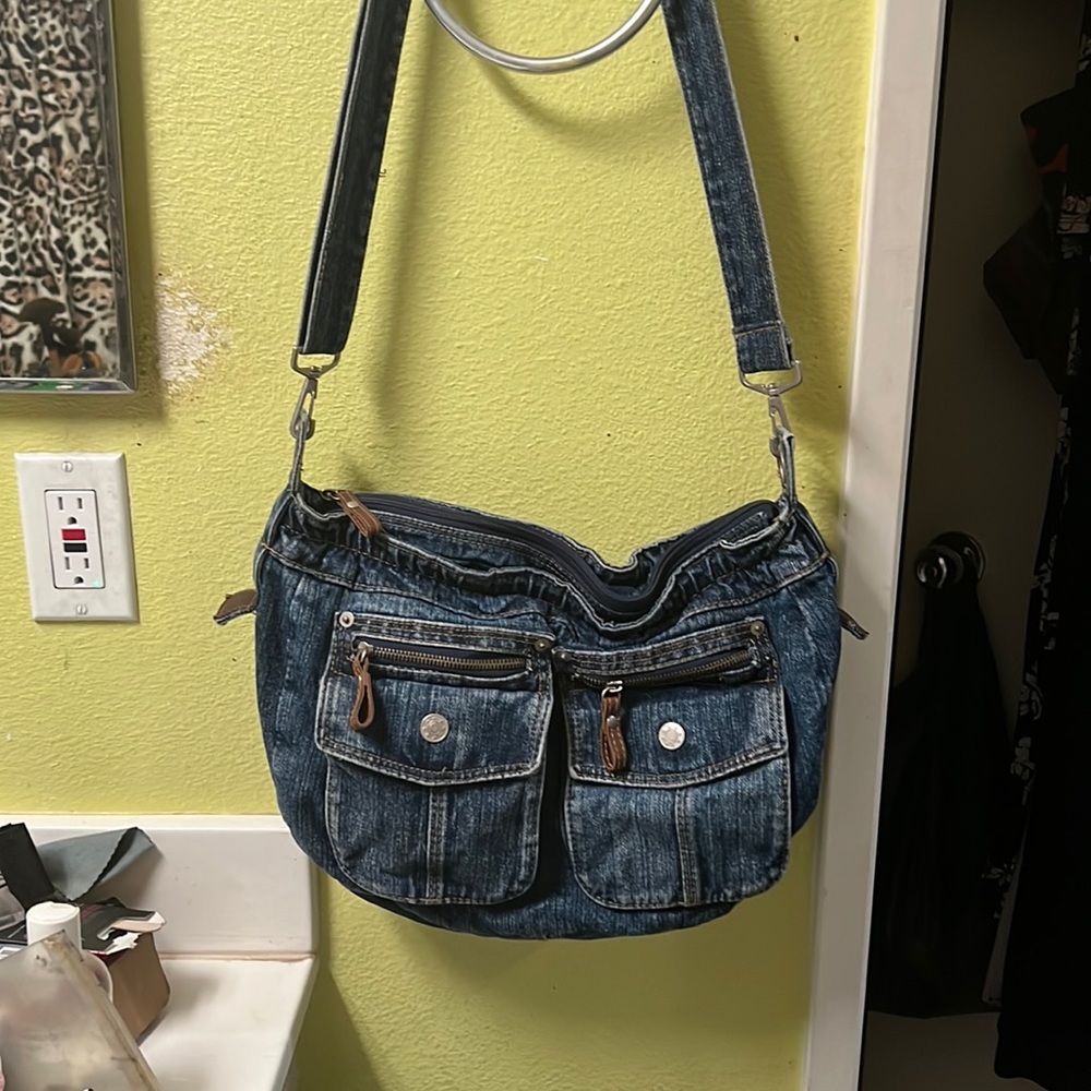 Beautiful denim blue bag with shoulder straps, pockets and leather details.
